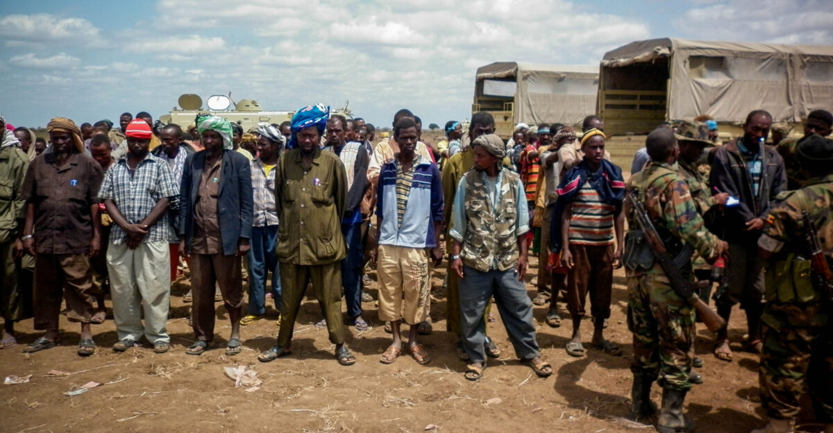 Members of the Al Qaeda-affiliated militant group Al Shabaab stand after giving themselves up to forces of the African Union Mission in Somalia AMISOM in Garsale approximately 10km from the town of Jowhar 80km north of the capital Mogadishu 22 September 2012 Over 200 militants disengaged following in-fighting between militants in the region in which 8 Al Shabaab were killed including 2 senior commanders The former fighters were peacefully taken into AMISOM s protection handing in over 80 weapons in the process in a further indication that the once-feared militant group is now divided and being defeated across Somalia Deputy Force Commander of AMISOM Operations Brigadier Michael Ondoga said a number of militants have contacted the AU force indicating their wish to cease fighting and that they their safety is assured if they give themselves up peacefully to AMISOM forces AU-UN IST PHOTO ABUKAR ALBADRI