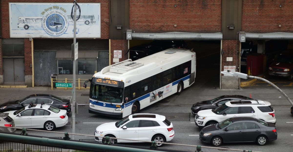 A B25 bus leaving the East New York Bus Depot fronting Jamaica Avenue looking from the Alabama Avenue BMT Jamaica Line station above Fulton Street at Georgia and Alabama Avenues in East New York Brooklyn