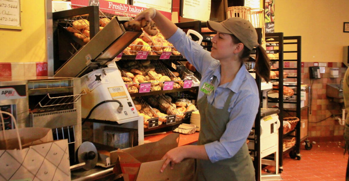 An employee places a bagel in a slicer machine at a Panera Bread restaurant in Cleveland Tennessee