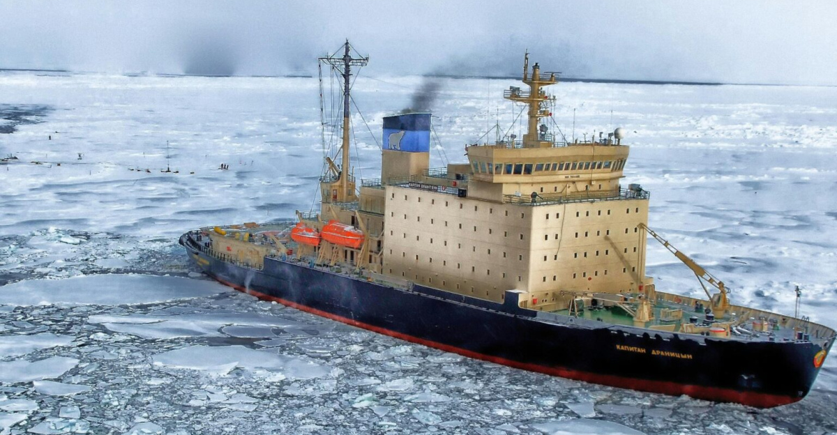 Icebreaker ship cutting through vast frozen ocean, showcasing winter exploration.