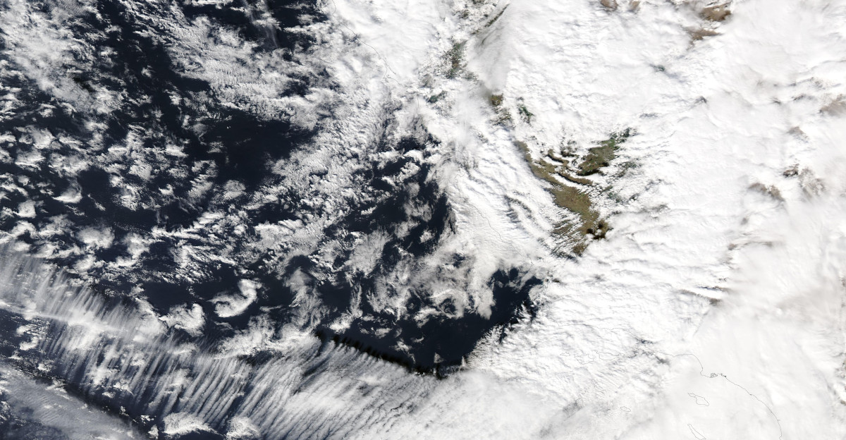A precipitation-filled atmospheric river struck southern California in mid-February 2025 kicking off the fifth coast-to-coast storm to strike the United States since the start of the new year Heavy rain drenched much of the region on February 12-14 including areas recently ravaged by wildfires Local media reported that on February 13 one highway intersection near Pacific Palisades was buried under at least 3 feet 1 meter of sludge It was also reported that a road near the Eaton Fire burn scar near Altadena California was covered in several feet of mud vegetation and trees despite a concrete block wall designed to prevent debris flows Several media outlets showed several cars mired in mud flows In the mountains the precipitation is in the form of heavy snow Mammoth Mountain In the Sierra Nevada mountains posted on Instagram on February 14 that it received about 6 feet 72 inches 183 cm in the previous 36 hours They also noted that two of its ski patrol staff were caught in an avalanche on that same morning The resort s website notes that risk of avalanche is extreme and the slopes will be closed on February 15 This strong system is expected to continue to disrupt conditions across the United States as it plows forward crossing the Rocky Mountains the Plains the Great Lakes States and eventually the Northeast over the upcoming weekend On February 13 the Moderate Resolution Imaging Spectroradiometer MODIS on NASA s Aqua satellite acquired this true-color image of the long atmospheric river arching northeastward over the Pacific Ocean to strike the southwestern coast of the United States The city of Los Angeles California is buried under the thickest area of cloud