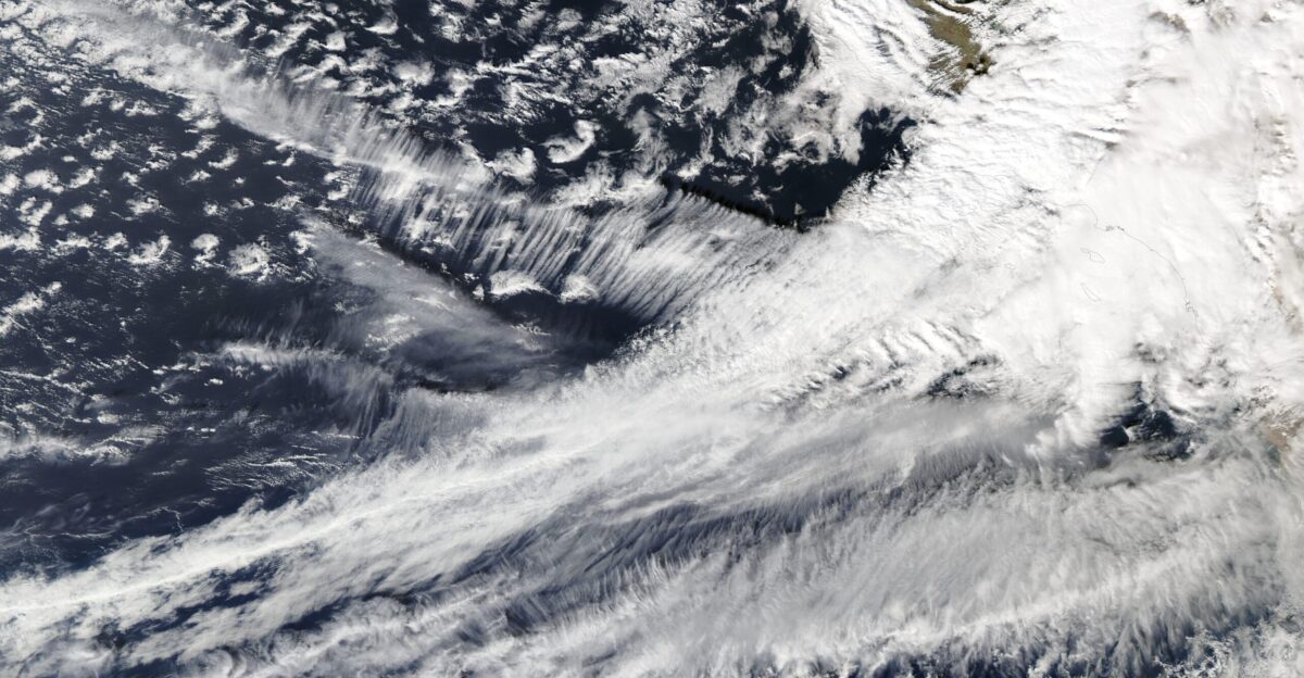 A precipitation-filled atmospheric river struck southern California in mid-February 2025 kicking off the fifth coast-to-coast storm to strike the United States since the start of the new year Heavy rain drenched much of the region on February 12-14 including areas recently ravaged by wildfires Local media reported that on February 13 one highway intersection near Pacific Palisades was buried under at least 3 feet 1 meter of sludge It was also reported that a road near the Eaton Fire burn scar near Altadena California was covered in several feet of mud vegetation and trees despite a concrete block wall designed to prevent debris flows Several media outlets showed several cars mired in mud flows In the mountains the precipitation is in the form of heavy snow Mammoth Mountain In the Sierra Nevada mountains posted on Instagram on February 14 that it received about 6 feet 72 inches 183 cm in the previous 36 hours They also noted that two of its ski patrol staff were caught in an avalanche on that same morning The resort s website notes that risk of avalanche is extreme and the slopes will be closed on February 15 This strong system is expected to continue to disrupt conditions across the United States as it plows forward crossing the Rocky Mountains the Plains the Great Lakes States and eventually the Northeast over the upcoming weekend On February 13 the Moderate Resolution Imaging Spectroradiometer MODIS on NASA s Aqua satellite acquired this true-color image of the long atmospheric river arching northeastward over the Pacific Ocean to strike the southwestern coast of the United States The city of Los Angeles California is buried under the thickest area of cloud