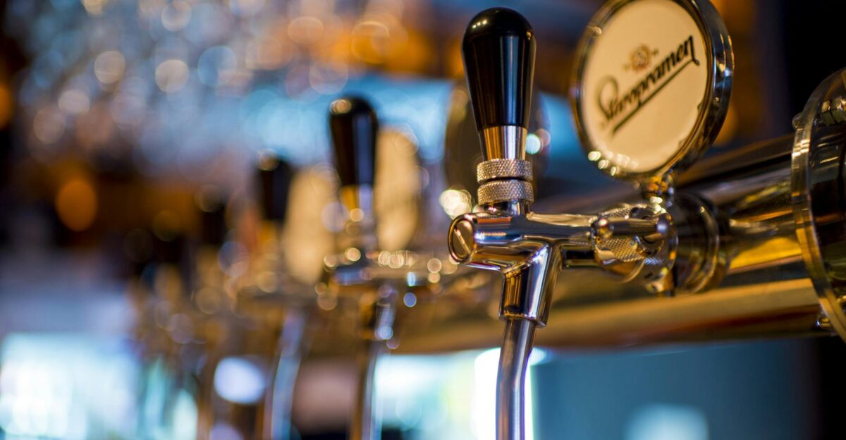 Focused image of a shiny beer tap in a stylish bar with a blurred background