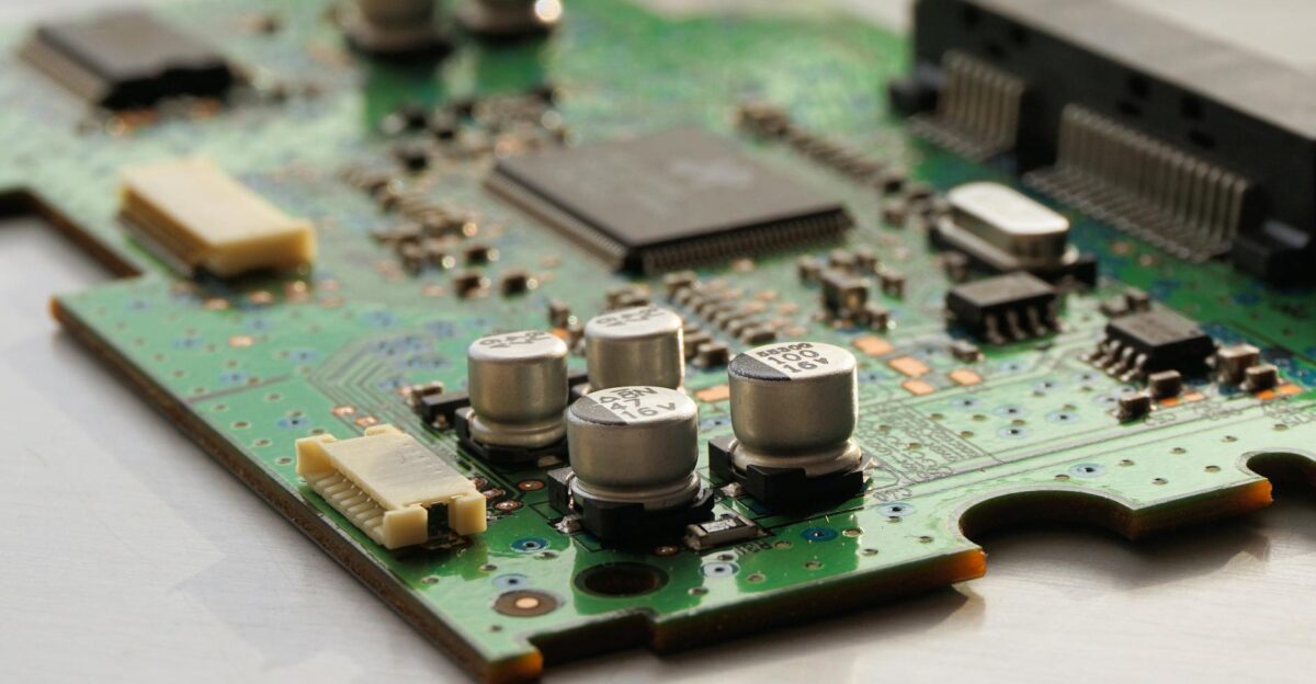 Detailed view of a green circuit board featuring capacitors and microchips