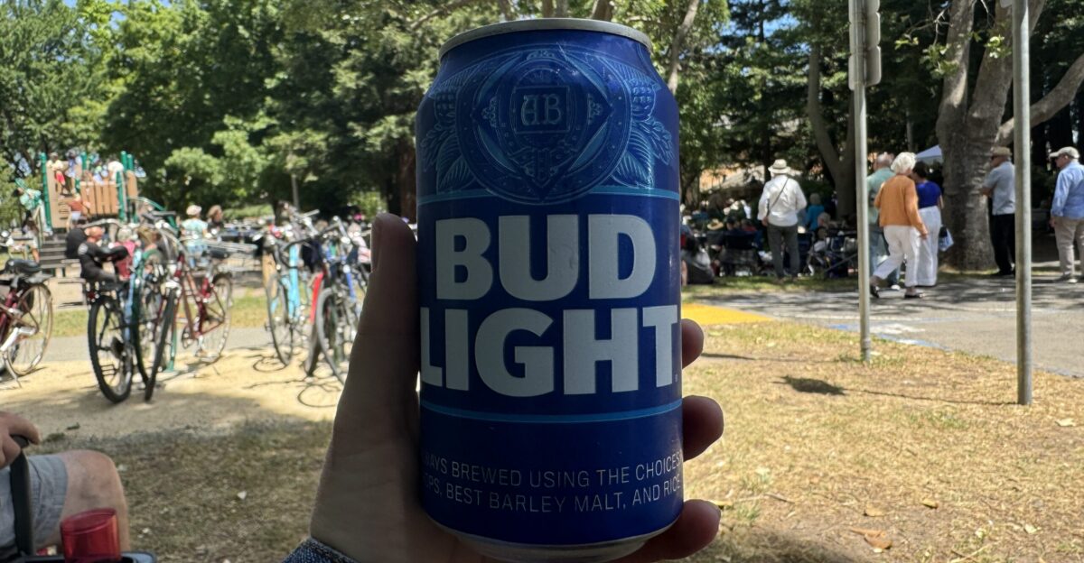 A hand holding a can of Bud Light