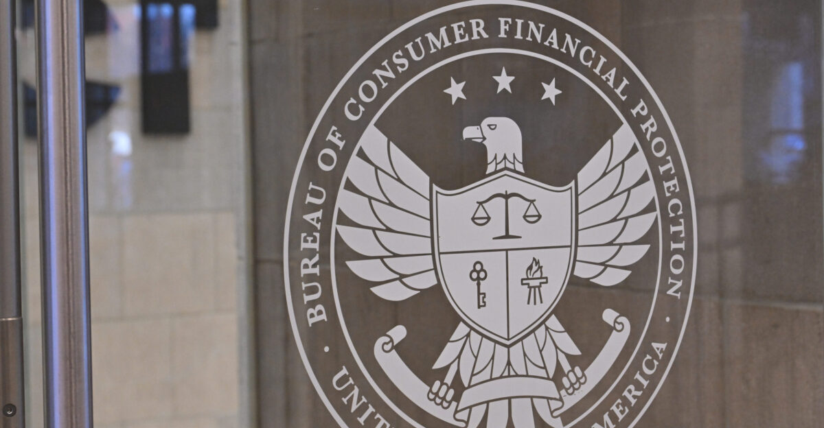 The logo for the Consumer Financial Protection Bureau on a glass door 1700 G Street NW Washington DC 20552