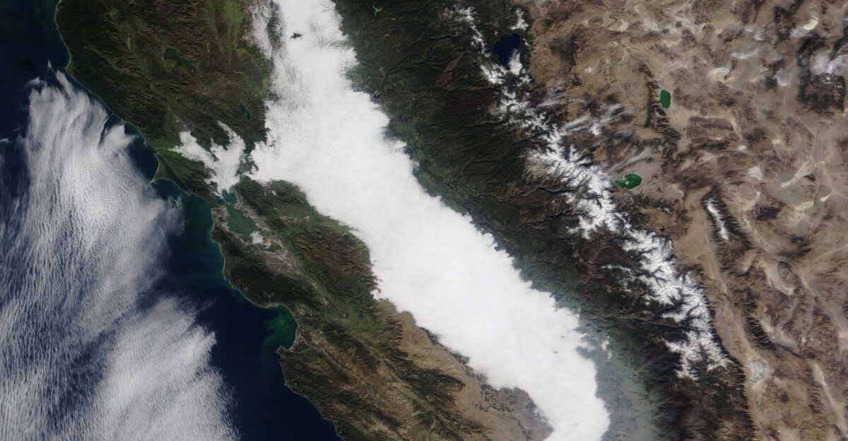 Winter moisture and cool weather created a dense fog over California s Central Valley on November 13 2021 The Moderate Resolution Imaging Spectroradiometer MODIS on board NASA s Terra satellite acquired a true-color image of the morning fog on that same day This fog known as tule too-lee is a frequent feature of winter in the Central Valley Although gorgeous to view from space the thick low cloud fog can be hazardous for people on the ground According to local media the National Weather Service issued a special very high transportation risk alert on the morning of November 13 The alert warned drivers to be prepared for traffic delays reduce speed use low beams and allow extra space between vehicles The formation of tule fog requires three ingredients wet ground still air and cold temperatures Conditions are ripe after the ground has become damp from a recent rain During the day the warmth of the Sun causes the moisture to evaporate into the air After sunset air temperature slowly drops Because cool air can hold less moisture than warm air the many tiny moisture droplets suspended in the air during the day combine into large droplets creating low cloud or fog Tule fog tends to form-often rapidly- after sunset become thickest just before dawn then slowly thins as the air warms in the morning Tule fog season typically begins in December and ends in February