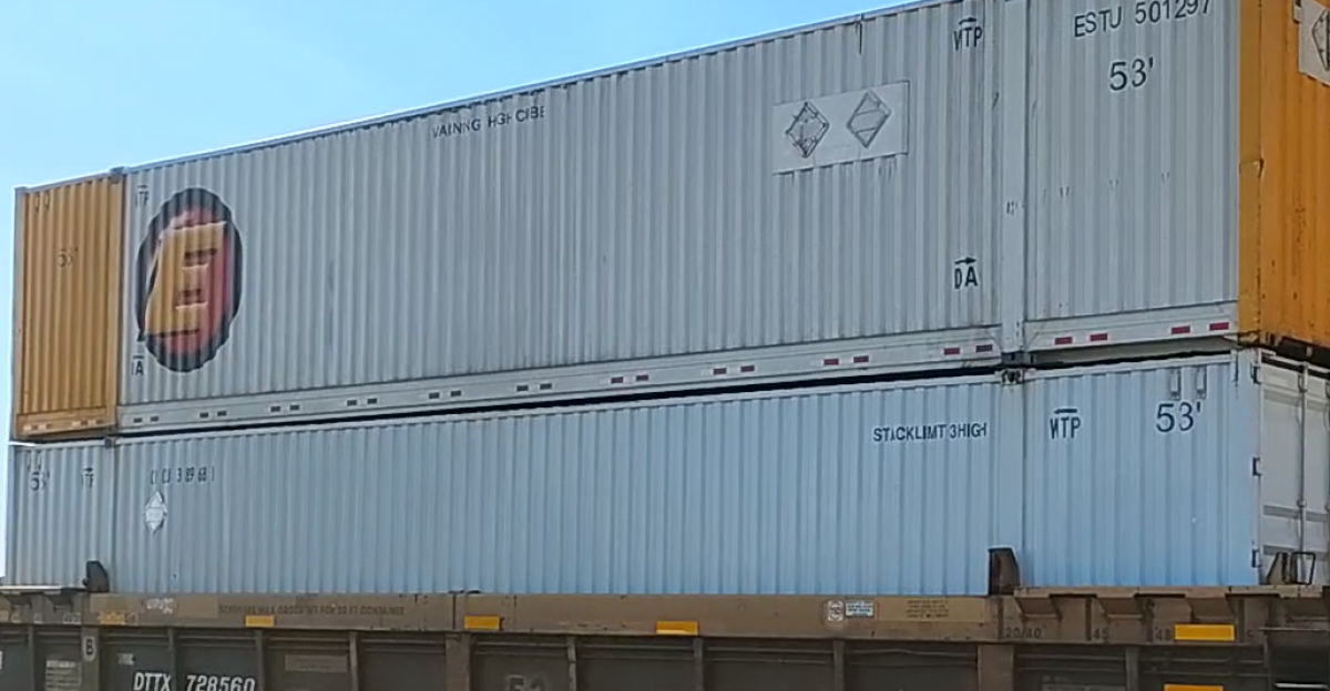Double stacked shipping containers in well freight cars