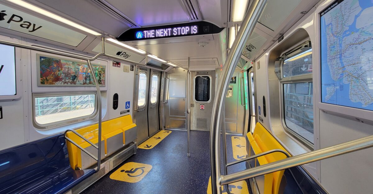 Inside R211 cab car No 4199 in Rockaway Park-Beach 116th Street-bound A service stopped at the Beach 105th Street-Seaside IND station above the Rockaway Freeway at Rockaway Beach Boulevard and Beach 106th Street in Seaside Rockaway Park Queens Due to the wider doors of the train the space between the driver s cab and the adjacent door is much smaller eliminating the designated wheelchair area To compensate the yellow row of seats folds up to accommodate wheelchair-bound passengers