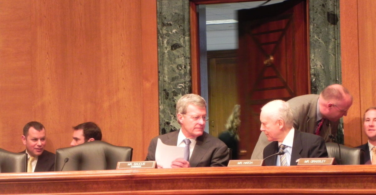 Baucus and ranking member Sen Orrin Hatch R-Utah talk before the committee hearing began Elena Schneider Medill News Service