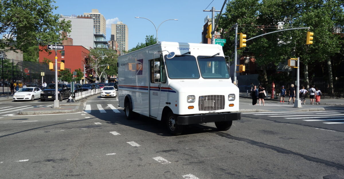 A typical USPS delivery truck traveling west on West Houston Street across Sixth Avenue in Greenwich Village SoHo Manhattan