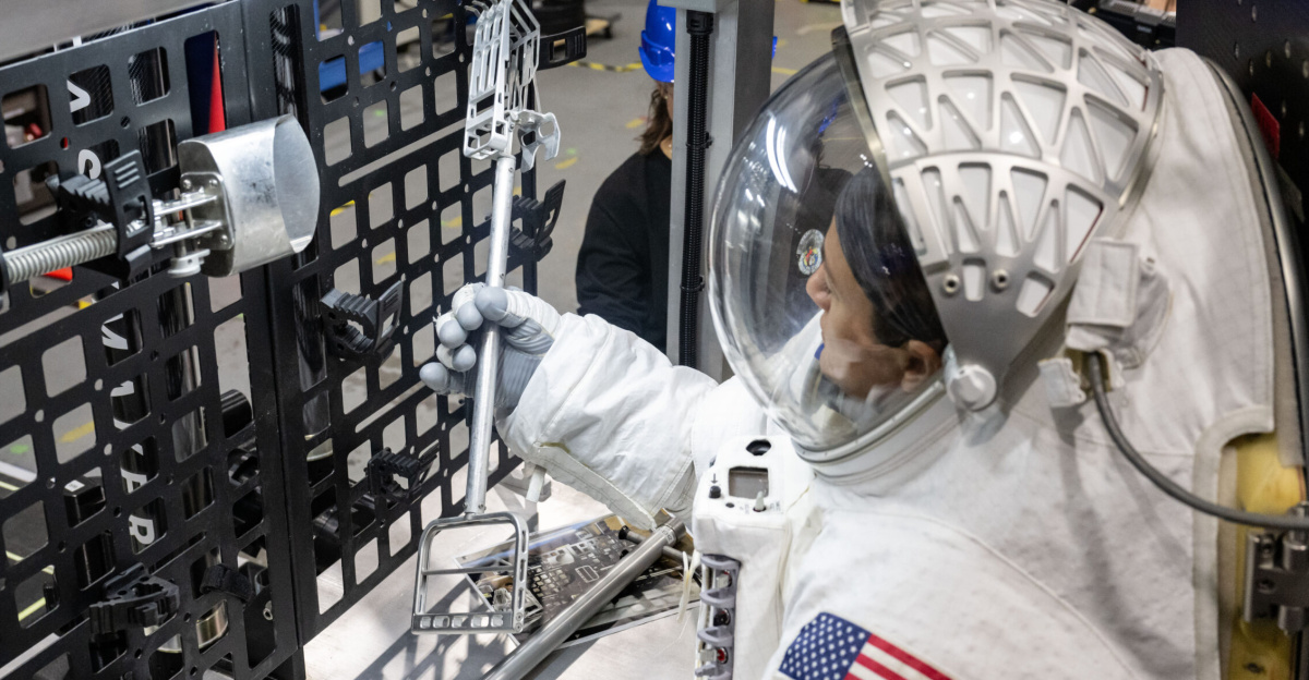 NASA astronaut Jessica Meir grabs a lunar geology tool from a tool rack on Lunar Outpost’s Eagle lunar terrain vehicle during testing at NASA’s Johnson Space Center. Image Credit: NASA/James Blair