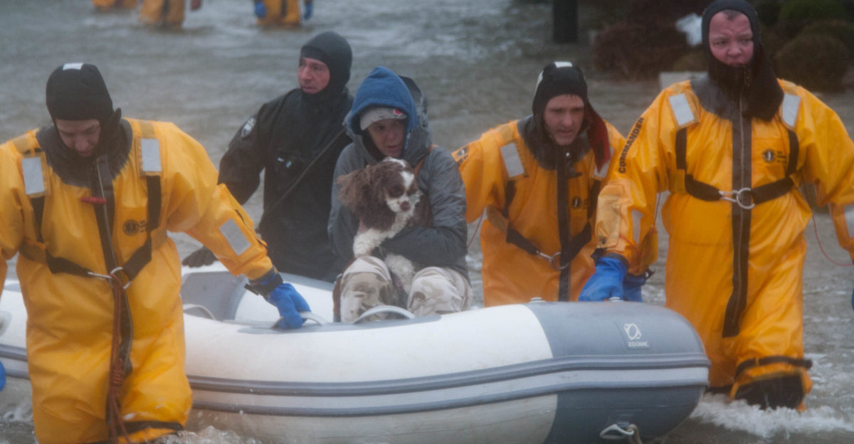 Rescuers evacuate a resident and dog from their home in Quincy, Mass. during a winter storm that hit the region Mar. 2, 2018.  Local authorities relied on Massachusetts National Guard members to transport victims of the flooding to safety using light medium tactical vehicles that could drive through the high water. (Photo by Spc. Samuel Keenan)