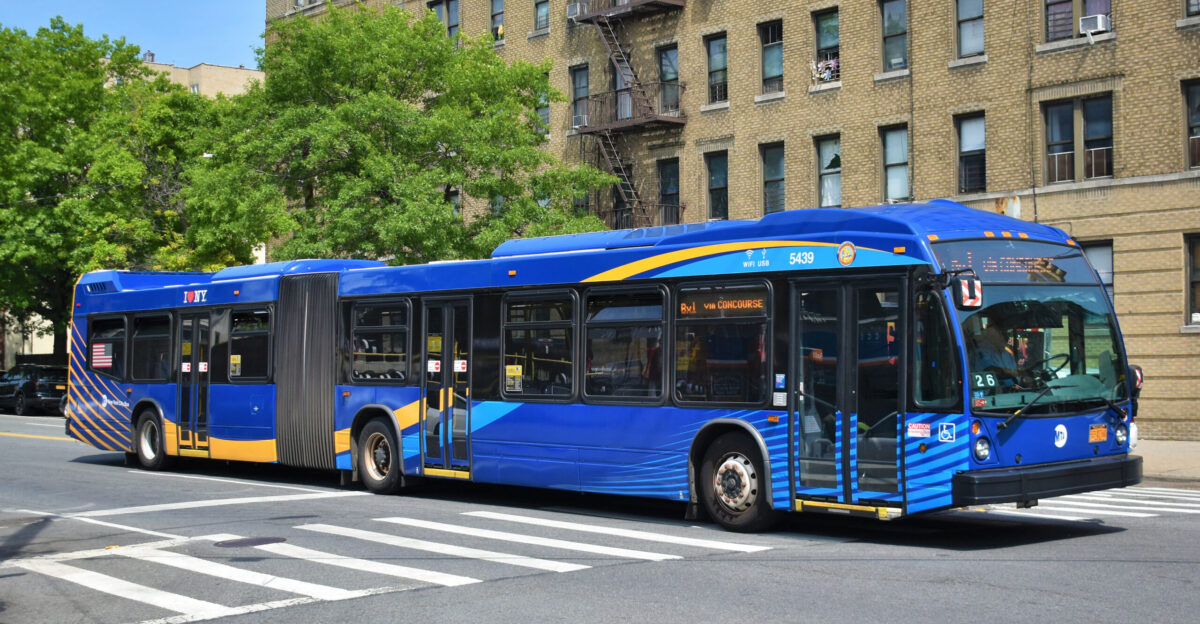 A driver of an MTA New York City Transit Nova Bus LFS articulated bus 5439 is preparing to turn left from Bailey Avenue onto Albany Crescent while operating along the Bx1 Limited in Kingsbridge due south to Mott Haven
