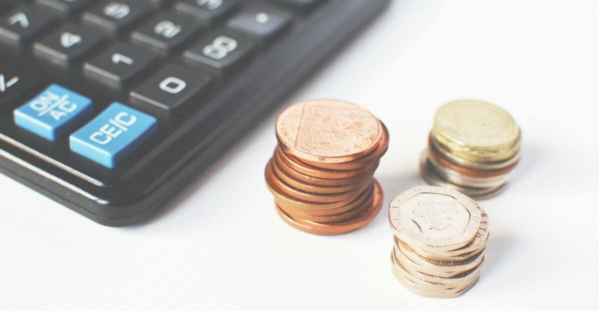 Close-up of stacked coins and a calculator symbolizing financial strategy and budgeting