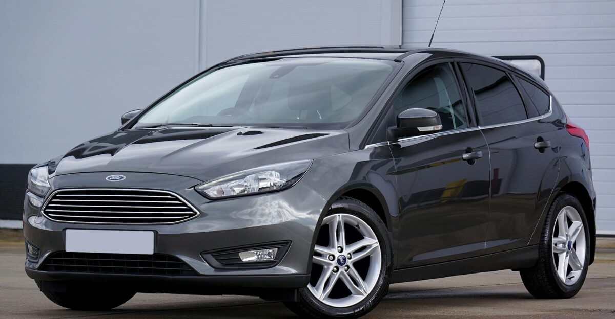 A sleek grey hatchback car parked outdoors showcasing its modern design and shiny finish