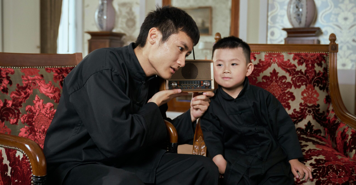 A father and son share a moment listening to a vintage radio in a retro-style living room.