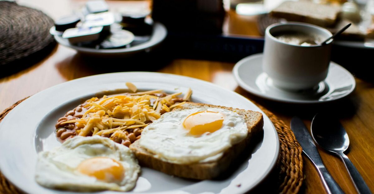 A hearty breakfast with fried eggs baked beans and toast served with coffee in a cozy setting