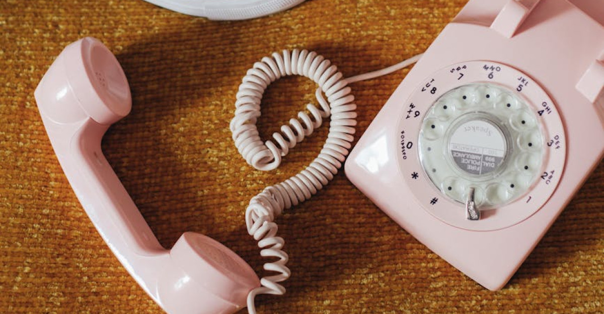 Vintage rotary phone beside stylish sneakers on colorful carpet evokes nostalgic 90s fashion