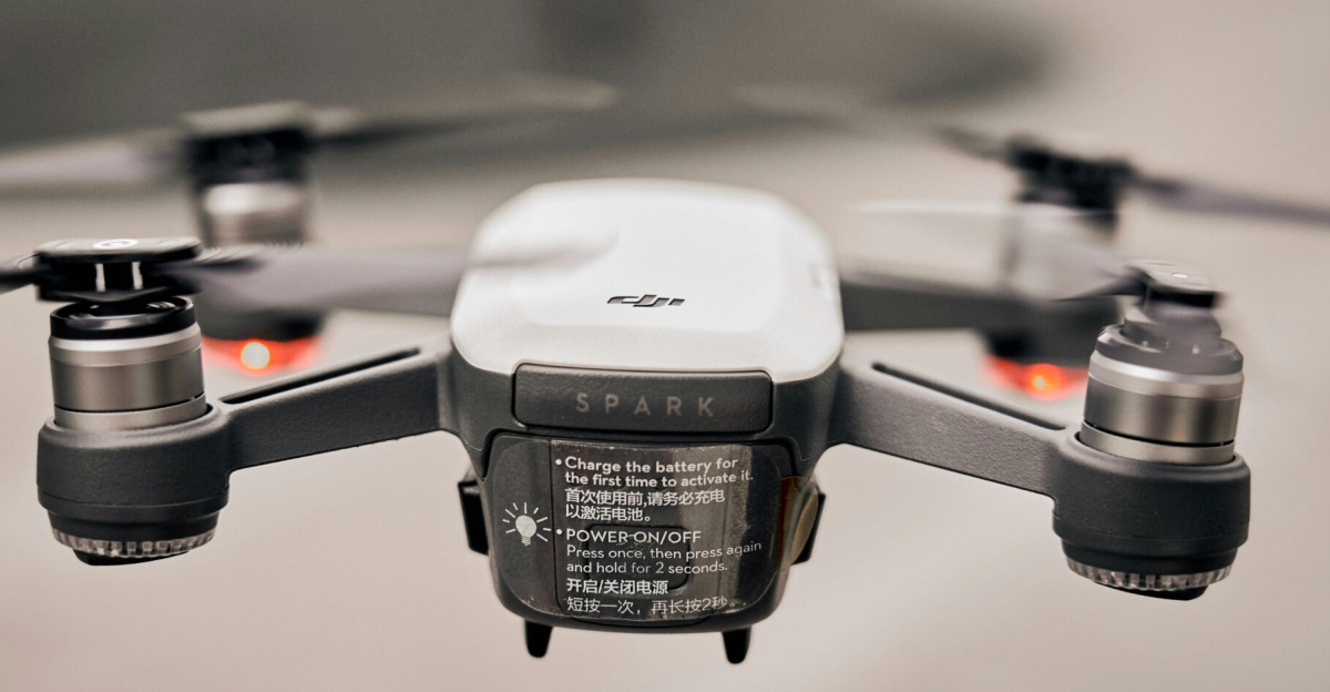 Close-up of a modern drone flying outdoors, showcasing advanced technology and propellers.