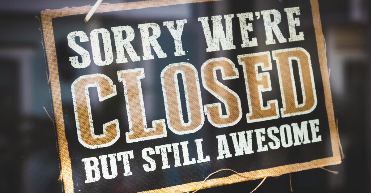 A playful closed sign on a shop door reading 'Sorry We're Closed But Still Awesome'.