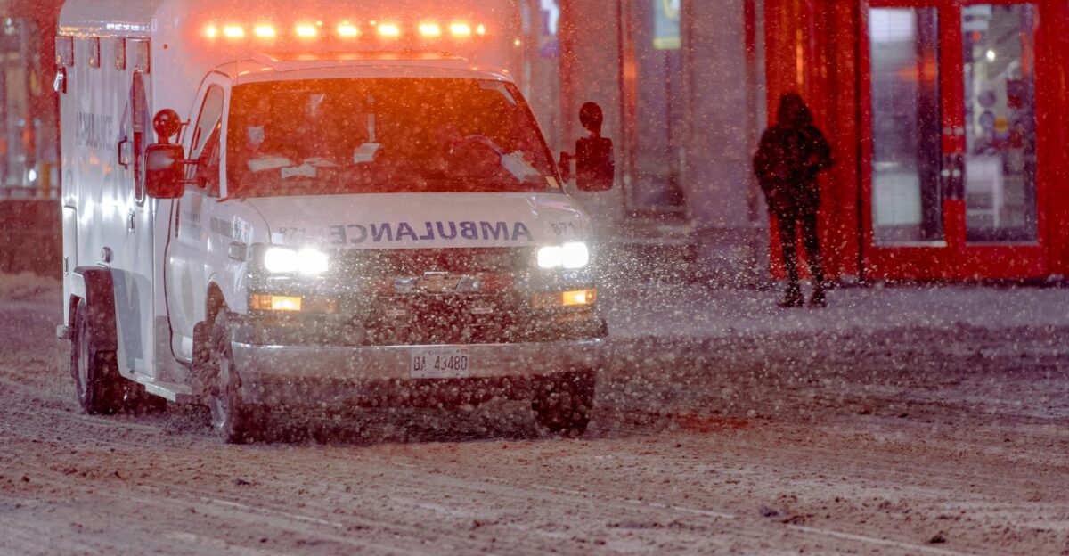 Ambulance on a snowy street during a winter emergency response at night