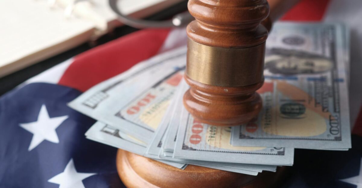 Close-up of a judge s gavel resting on US dollar bills and an American flag symbolizing justice and finance