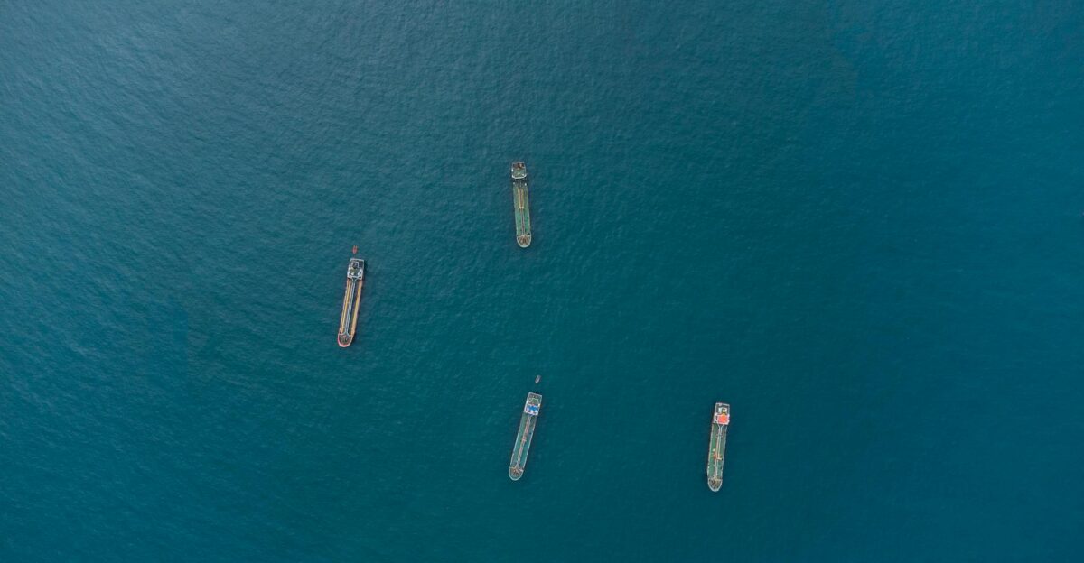 Top-down view of four cargo ships on vast ocean showcasing maritime transport
