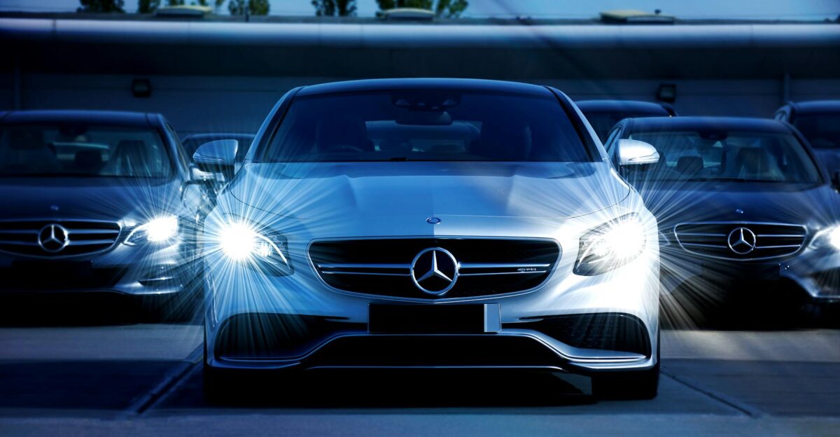 Front view of a lineup of Mercedes-Benz cars with bright headlights showcasing luxury and elegance