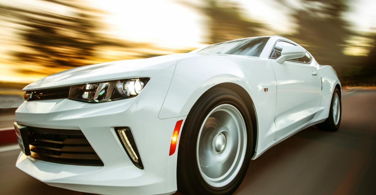 A white sportscar in motion showcasing speed and style on an open road