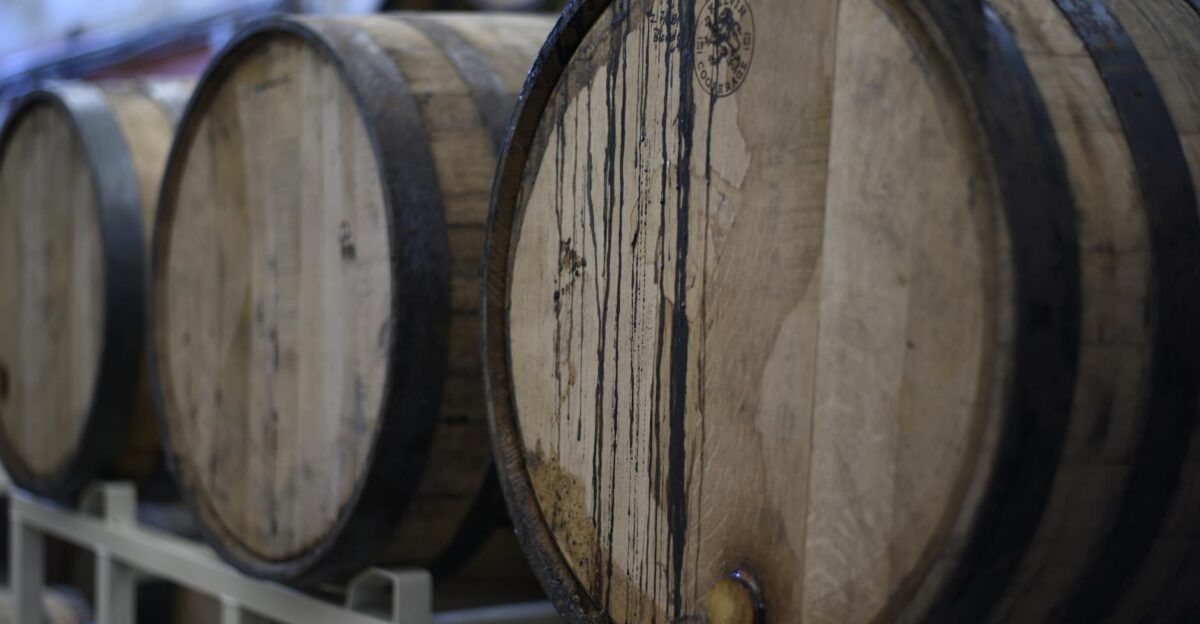 Close-up of wooden wine barrels used for fermentation and storage in a winery cellar