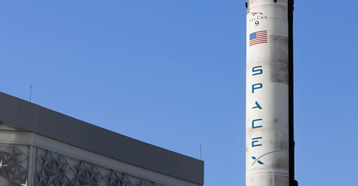 A SpaceX Falcon 9 rocket displayed outdoors against a clear blue sky in Dubai.