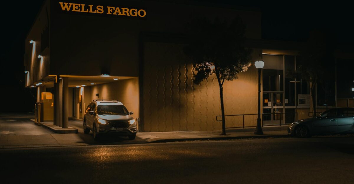 Illuminated Wells Fargo bank branch at night showcasing modern architecture and signage