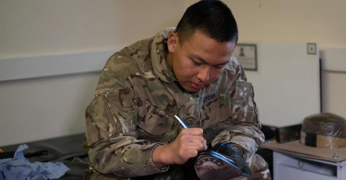 A British soldier is polishing boots indoors showcasing military routine and discipline