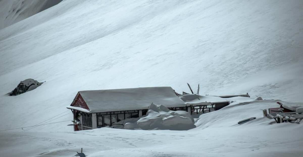 A solitary building buried under snow illustrating the aftermath of an avalanche