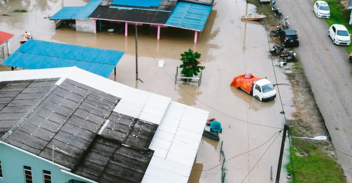 Aerial view of a flooded village in Kijal, Terengganu, Malaysia, showcasing submerged houses and streets.