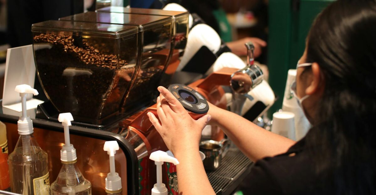 Barista expertly prepares a coffee shot in a bustling caf environment