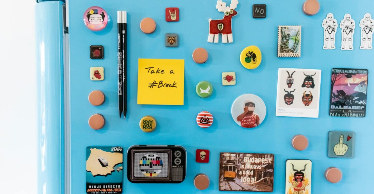 A vibrant collection of magnets on a blue fridge featuring souvenirs and a sticky note reading Take a Break