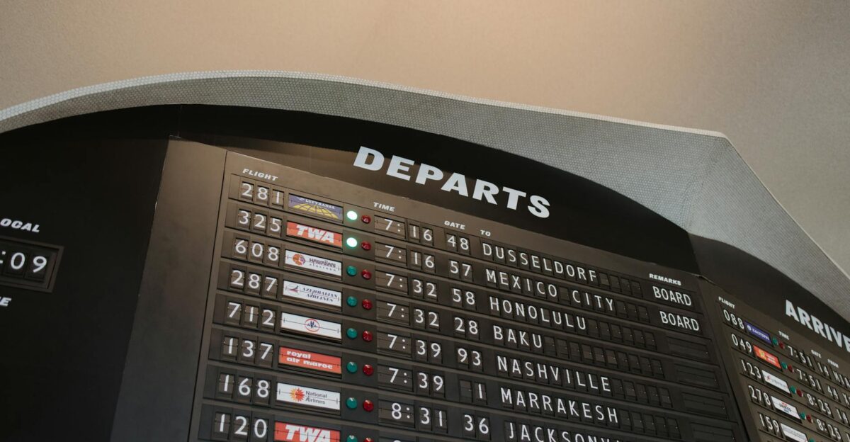 Close-up of airport departure board displaying flight details at JFK Airport New York