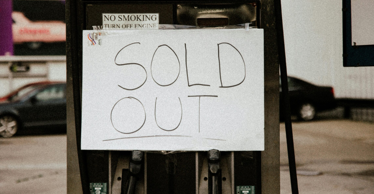 A gas pump at an urban station displaying a 'Sold Out' sign, illustrating fuel shortage.