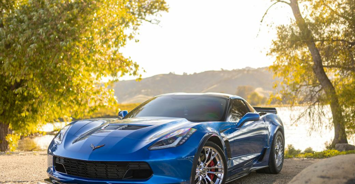 Stunning blue Chevrolet Corvette Z06 parked by a serene lake in rural setting