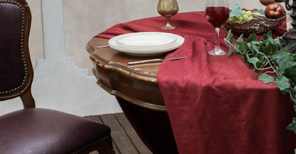 Vintage dining setting with red tablecloth empty plates and ornate decor perfect for elegant interior design themes