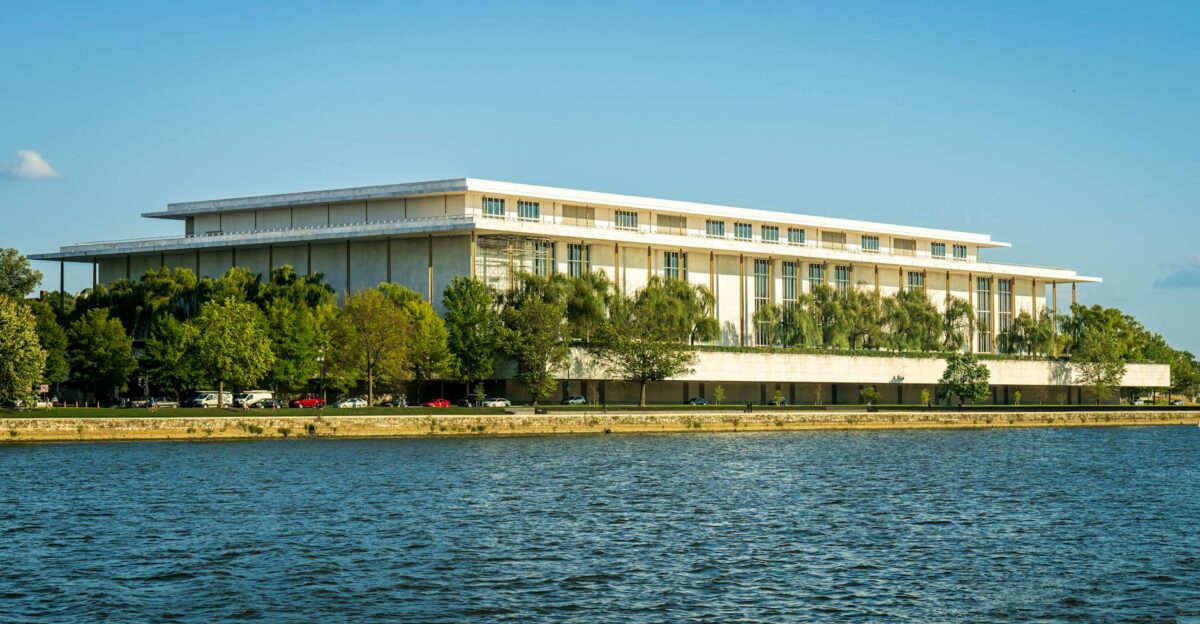 Captivating view of the Kennedy Center beside the Potomac River with lush greenery in summer