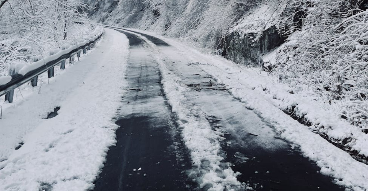 A serene snow-covered road curves through a wintery forest in Tennessee