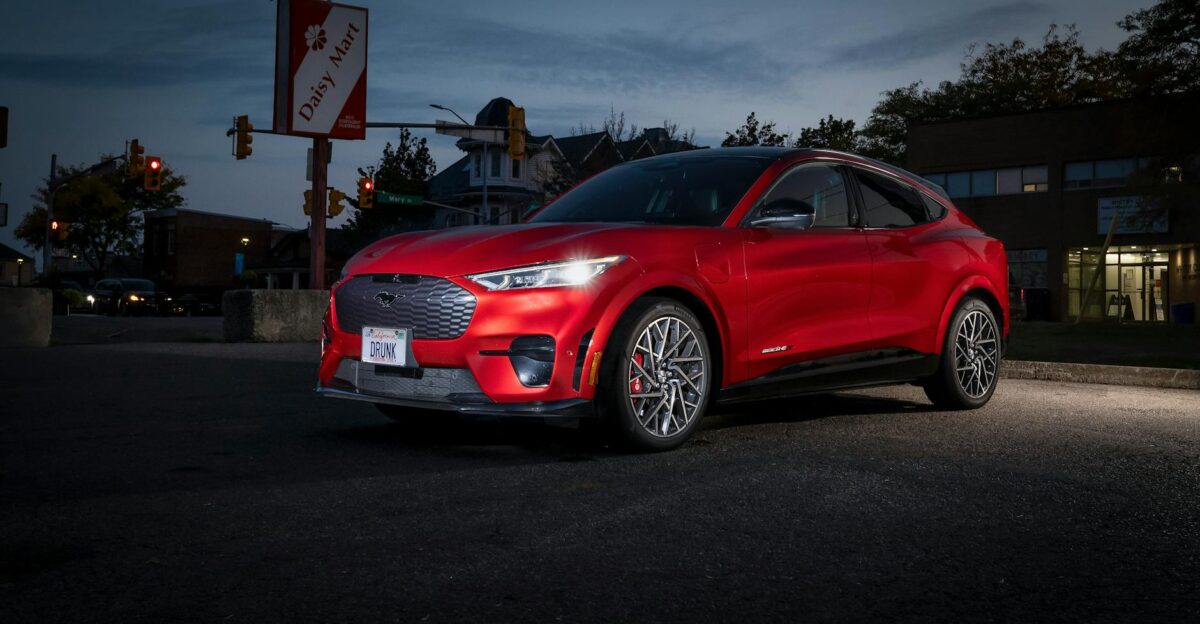 Red Ford Mustang Mach-E electric SUV parked at night in an urban setting