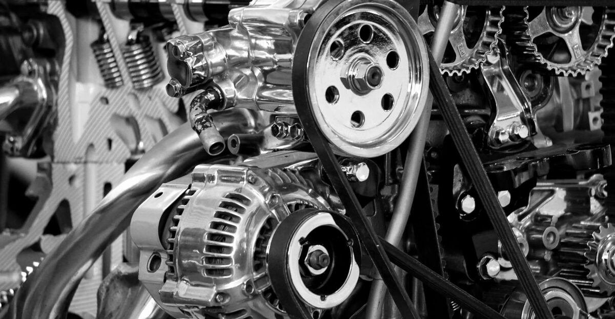 Close-up of a shiny car engine showing polished metal parts and gears in black and white