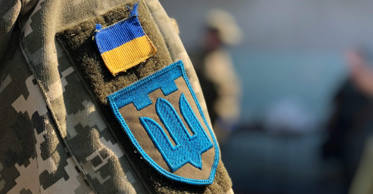 Close-up of a military uniform displaying Ukrainian insignia outdoors.