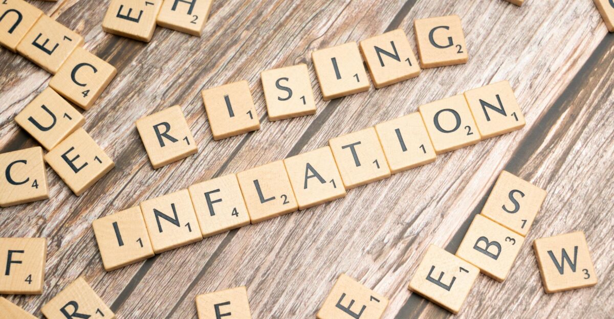 Wooden letter tiles spell rising inflation symbolizing economic concerns