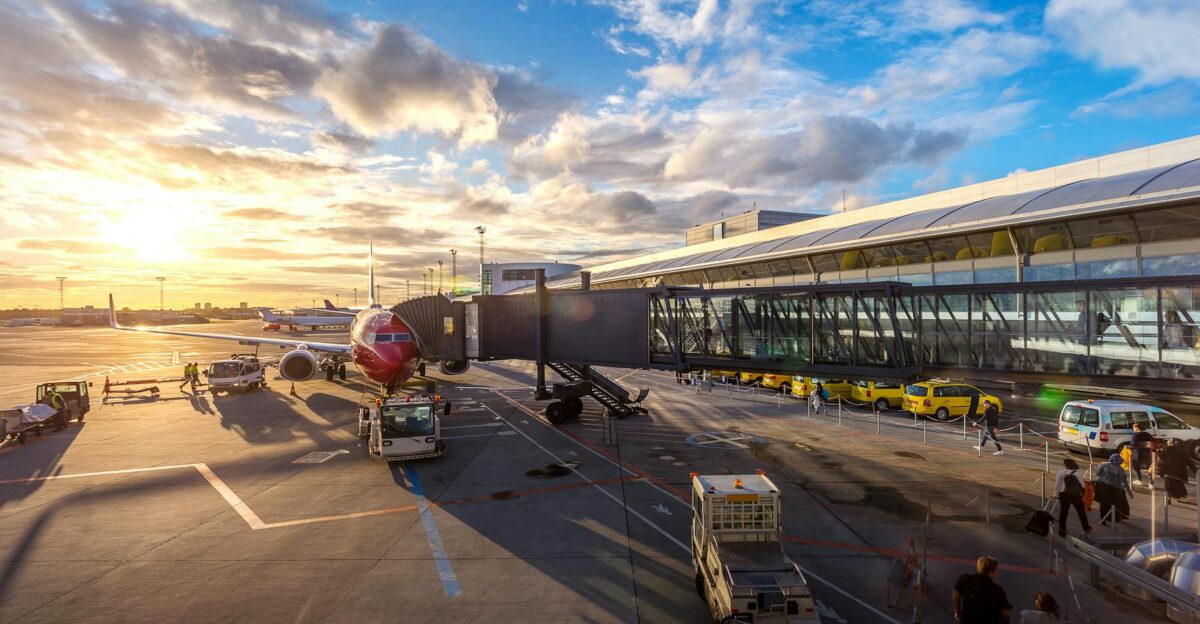 A vibrant sunset at Copenhagen Airport with airplanes and bustling activity