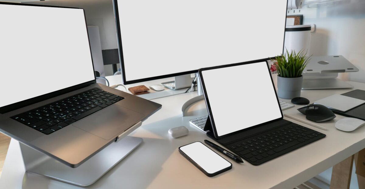 A clean and modern workspace featuring a laptop tablet smartphone and monitor Ideal for remote work and tech setups